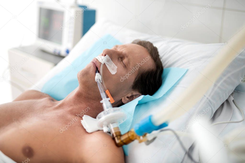 Patient on mechanical ventilation lying in bed