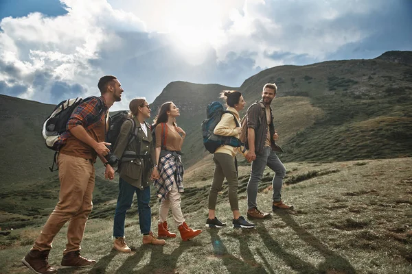 Fem unga vandrare promenader i bergen och leende — Stockfoto