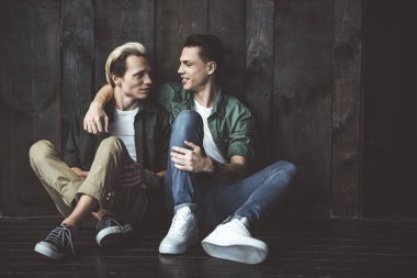 Ahşap arka plan üzerinde sarılma güzel gay çift