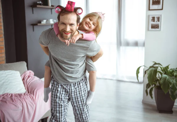 Pai alegre segurando filha nas costas enquanto joga — Fotografia de Stock