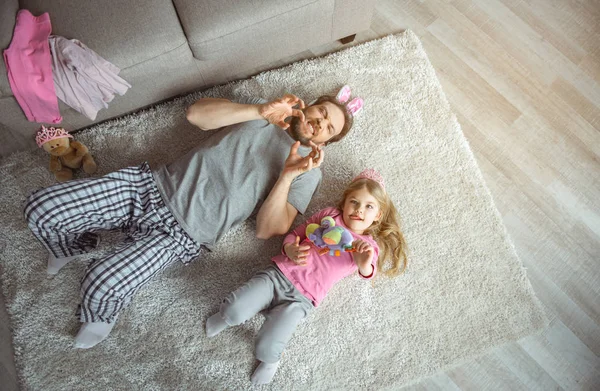 Alegre papá y niña jugando en la alfombra en el apartamento — Foto de Stock