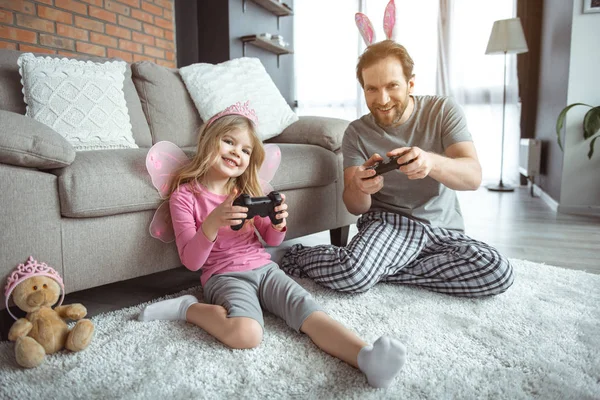 Padre e hija emocionados jugando videojuegos en casa — Foto de Stock