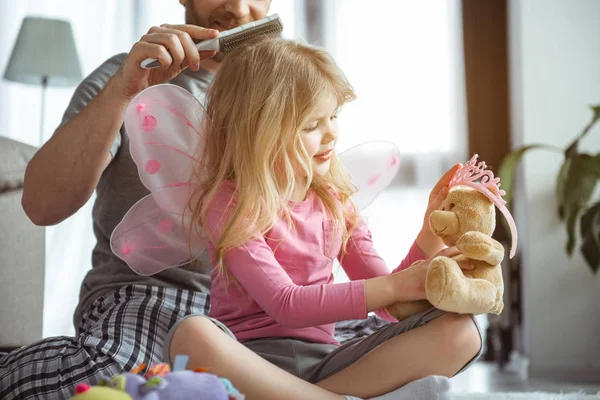 Krásná dívka si hraje s hračkami poblíž její táta — Stock fotografie