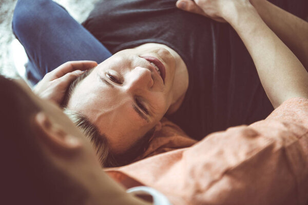 Любящие гей-пары отдыхают вместе на диване дома
