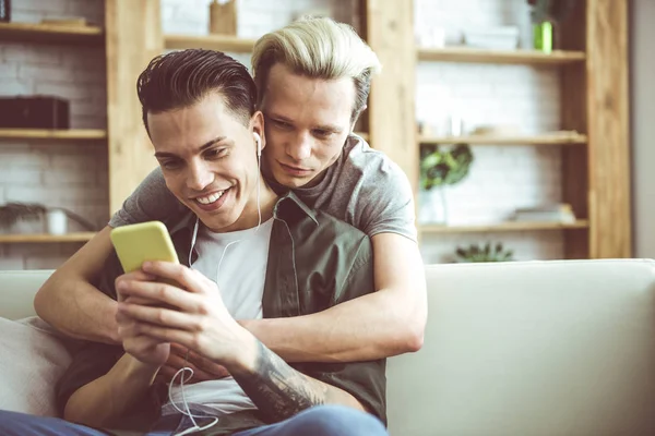 Feliz pareja gay abrazándose y viendo videos en el teléfono inteligente —  Fotos de Stock