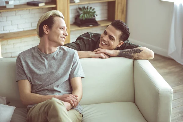 Loving gay couple looking at each other with happy smiles