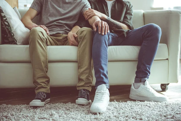 Amar pareja gay sentado en sofá cerca el uno del otro —  Fotos de Stock