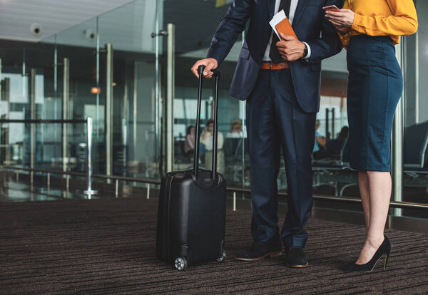 Бизнесмен, стоящий рядом со своим помощником в зале ожидания
