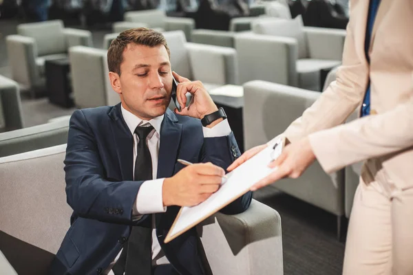 L'homme occupé en costume signe des documents. — Photo