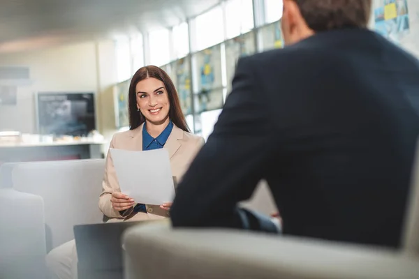 Vrolijke dame op zakelijke bijeenkomst met tegenstander in café — Stockfoto