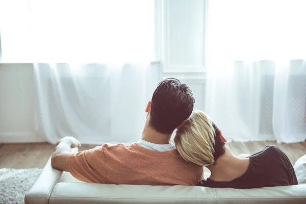 Loving gay couple resting on couch and cuddling Stock Picture