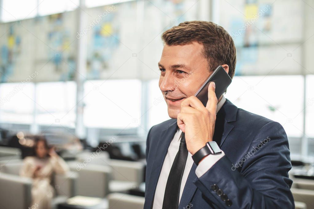 Busy man speaking on phone with smile