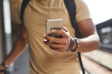 Online arkadaşları temas olurken telefonu kullanarak hoş bir adamın seçici odak