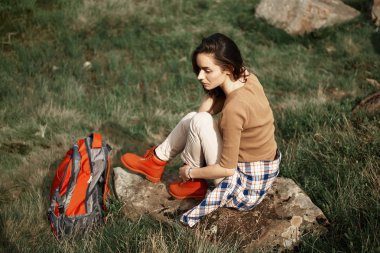 Üstten görünüm oturan ve bir taş üzerinde rahatlatıcı sakin Lady. Kayalık kırsal yoluyla sırt çantası ile hiking