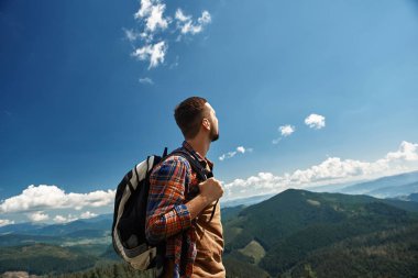 Highland tur sırasında sırt çantası taşıyan adam. O üstte duran ve yokuş aşağı izlerken