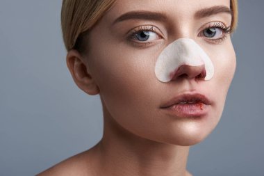 Üzgün kadın kan dudak ve burun yaparken bakıyorsun