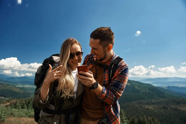 Vrolijke paar is het gebruik van smartphone in Bergen — Stockfoto