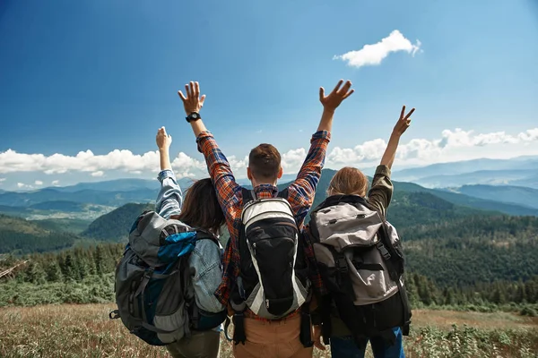 Три активні туристи вітають гори разом — стокове фото