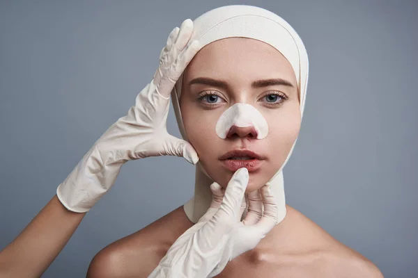 Handen in rubberen handschoenen aanraken van de lippen van de jonge dame — Stockfoto