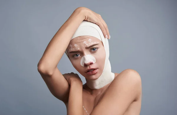 Traurige Dame, die ihren Kopf berührt, während sie Bandagen trägt — Stockfoto