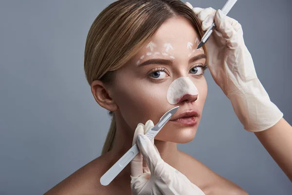 Rustige vrouw draaien haar hoofd en chirurgen werken met haar gezicht — Stockfoto