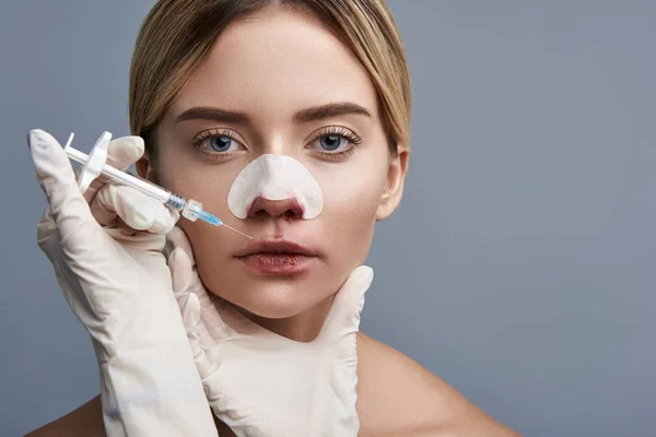 Close up de mulher séria olhando para você e recebendo injeção — Fotografia de Stock