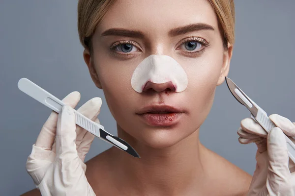 Dame met bloedige lippen hebben twee scalpels in de buurt van haar gezicht — Stockfoto