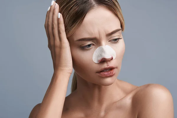 Vrouw met bloedige gezicht fronsen en lijden aan hoofdpijn — Stockfoto