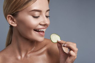 Salatalık dilim bakarken gülümseyen genç bayan