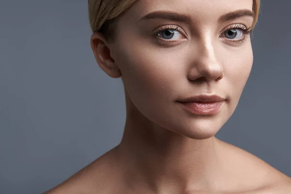 Primer plano de una mujer guapa mirándote y sonriendo un poco — Foto de Stock