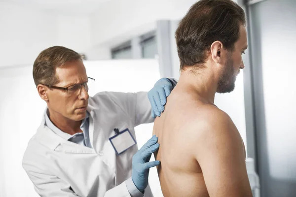 Läkare att noggrant undersöka ryggraden av patient — Stockfoto