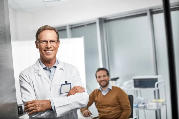 Médico sonriente está de pie en su oficina — Foto de Stock