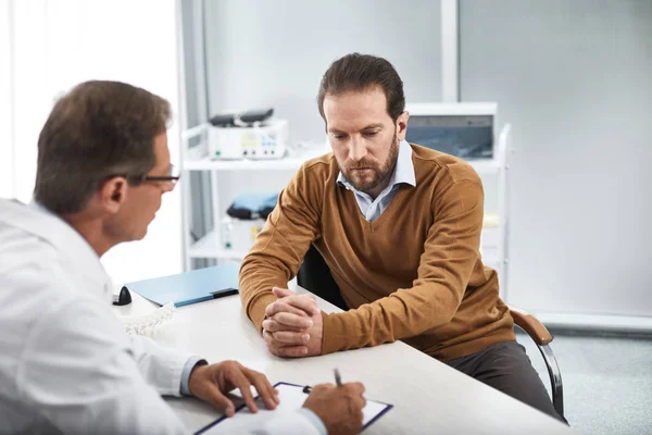 Consulente medico che consulta il paziente di sesso maschile nel gabinetto — Foto Stock