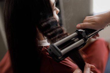 Stilist kadın berbere kilitlerine yapıyor