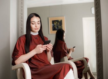 Sakin kadın güzellik stüdyosu cep telefonu kullanıyor