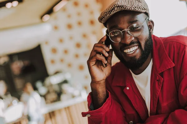 Jonge man praten aan de telefoon en lacht vrolijk met baard — Stockfoto