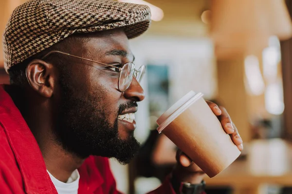 Close up van een bebaarde man glimlachend en koffie drinken — Stockfoto