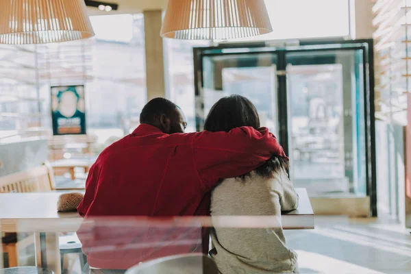 Uomo gentile che abbraccia la sua ragazza mentre è nel caffè con lei — Foto Stock