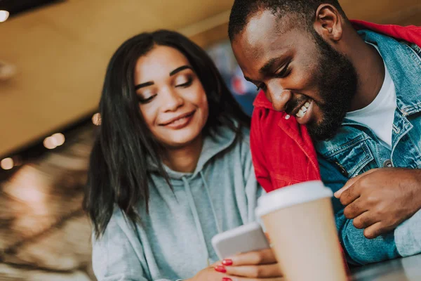 Jeune couple souriant et regardant l'écran du smartphone — Photo