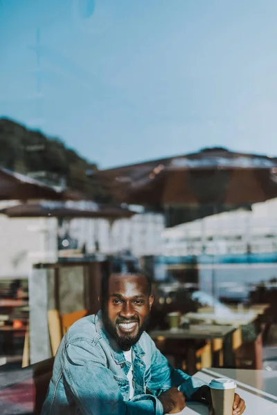 Knappe man glimlachen en kijken naar je zittend met kopje koffie — Stockfoto