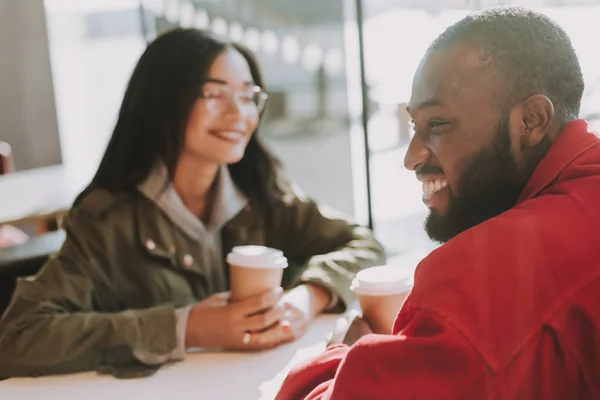 Homme positif riant tout en étant assis avec sa petite amie dans le café — Photo