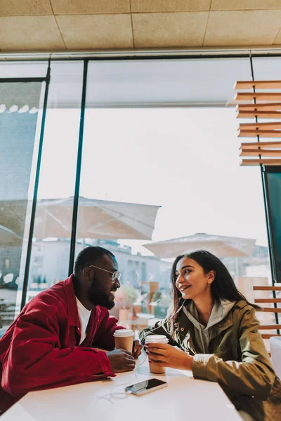 Позитивна фотографія молодої пари, яка посміхається під час перебування в кафе — стокове фото