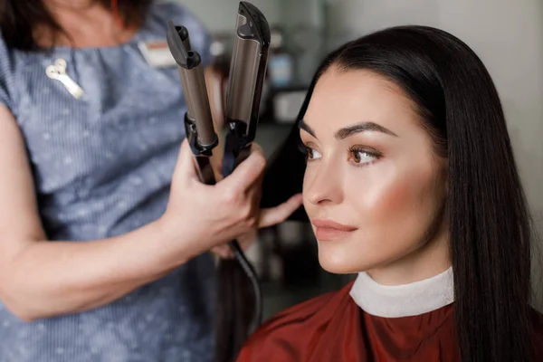 Grinande kvinna är att få håret gjort med zhuzh i salong — Stockfoto