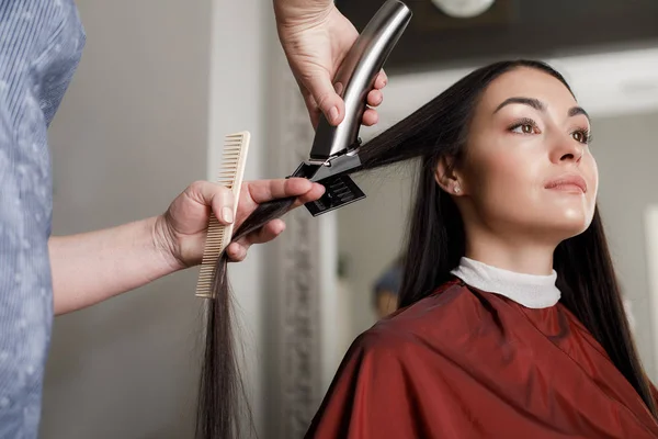 Mulher serena está tendo cabelo laminado por profissional — Fotografia de Stock