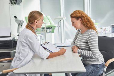 Kızıl saçlı Bayan doktorla masada otururken Pano arıyorum