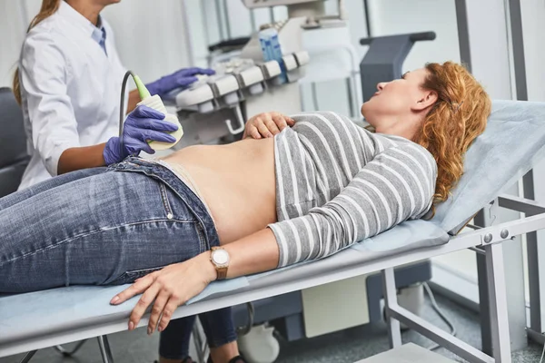 Femme d'âge moyen allongée sur un lit de repos pendant la procédure d'échographie — Photo