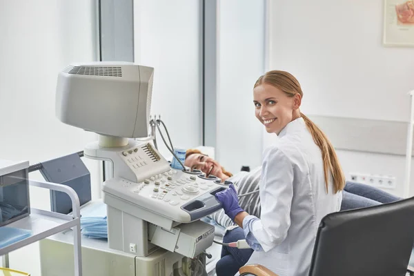 Médico alegre fazendo procedimento de ultrassonografia para senhora madura — Fotografia de Stock