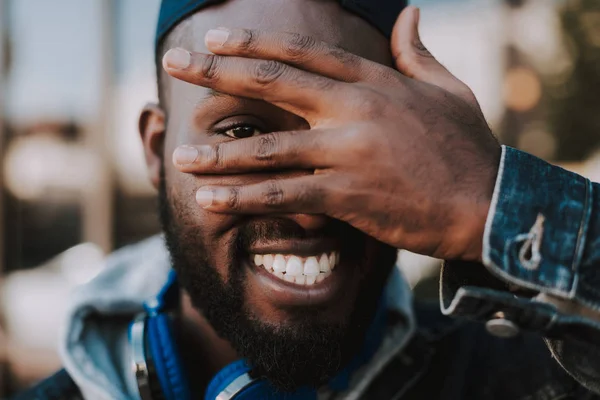 Vrolijke afro Amerikaanse man die zijn hand op het gezicht — Stockfoto