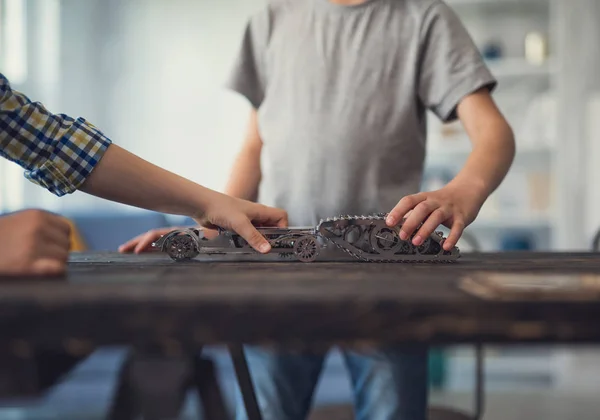 Close-up van twee jongens spelen met speelgoed mechanismen op tafel — Stockfoto