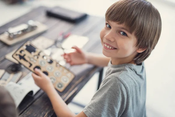 Niño feliz sonriendo a usted mientras juega con constructor de madera — Foto de Stock